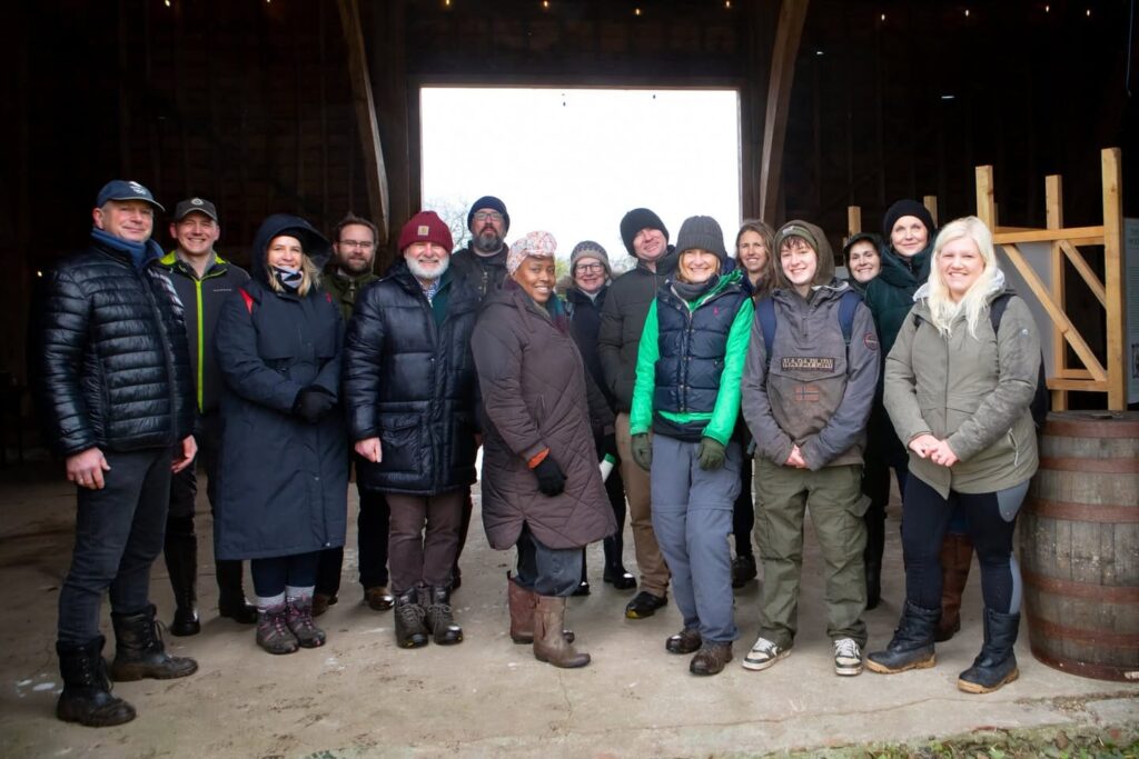 A group of 15 people wrapped up warm standing in the doorway of Woodoaks Black Barn.